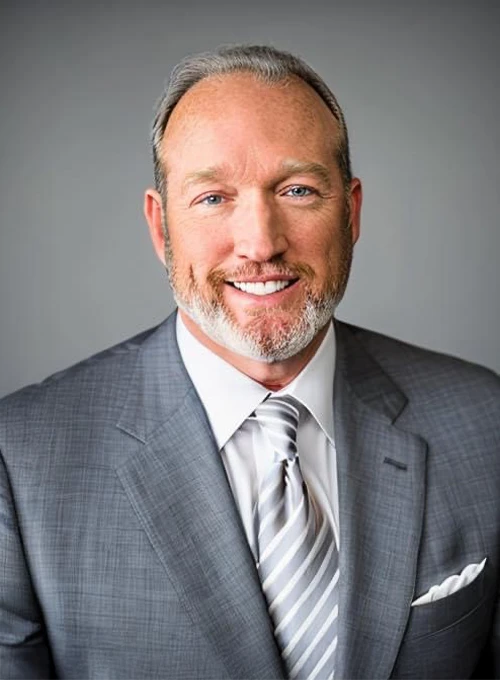 A professional photo of Dr. Vernon Millspaugh wearing a suit