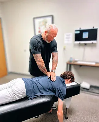 Chiropractor Edmond OK Vernon Millspaugh Upper Back Adjustment Dr. Vernon Millspaugh performing an adjustment on a patient's upper back and shoulders